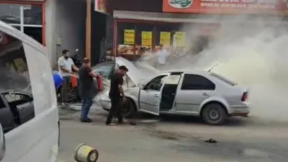 Adana’da yanan otomobili esnaf su ve yangın tüpüyle söndürdü